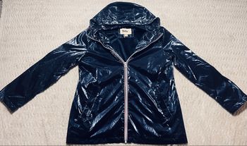 Veste légère et brillante de couleur bleu marine, avec capuche.