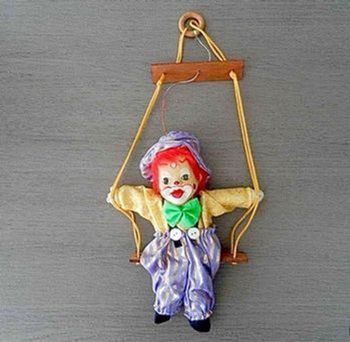 Clown tête porcelaine sur balançoire