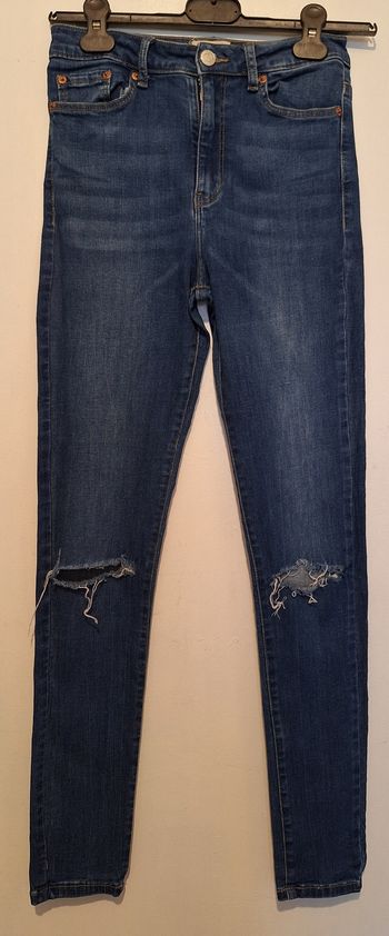 Jean skinny bleu avec les genoux troués