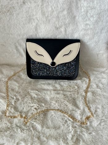 Sac à main renard à bandoulière, couleurs noir, beige, argenté et bleu. Bandoulière en métal doré Dimensions : largeur 19 cm x hauteur 15 cm x épaisseur 5 cm Neuf