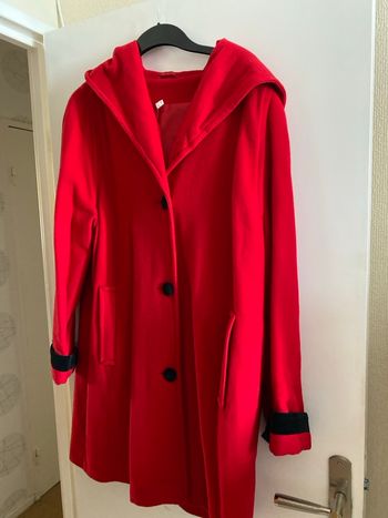 Manteau rouge avec le  bord des manches noires et capuche