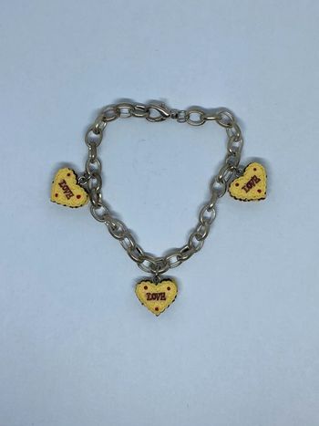 Bracelet fantaisie avec 3 gâteaux en forme de Coeur, et noté Love sur une face.
