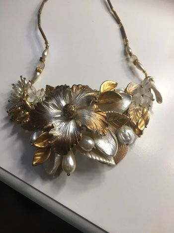 collier fleurs dans les tons dorés et blanc