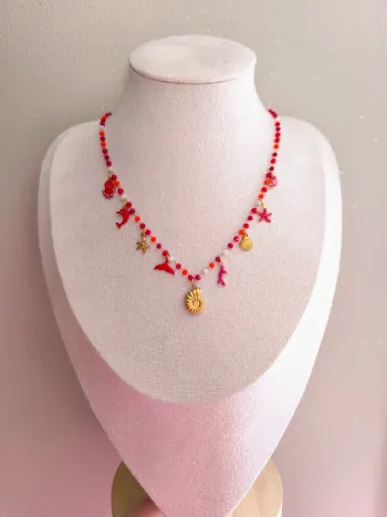 Collier doré et rouge avec perles de cristal et breloques de la mer