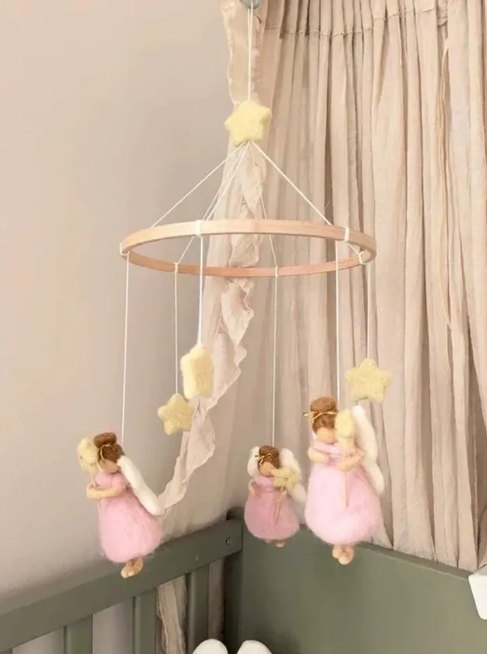Mobile suspendu avec motifs de petites fées roses et d’étoiles pour bébé.