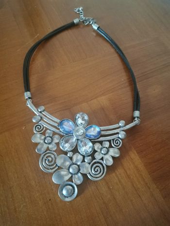 Collier plastron fleurs argentées et strass sur câble noir