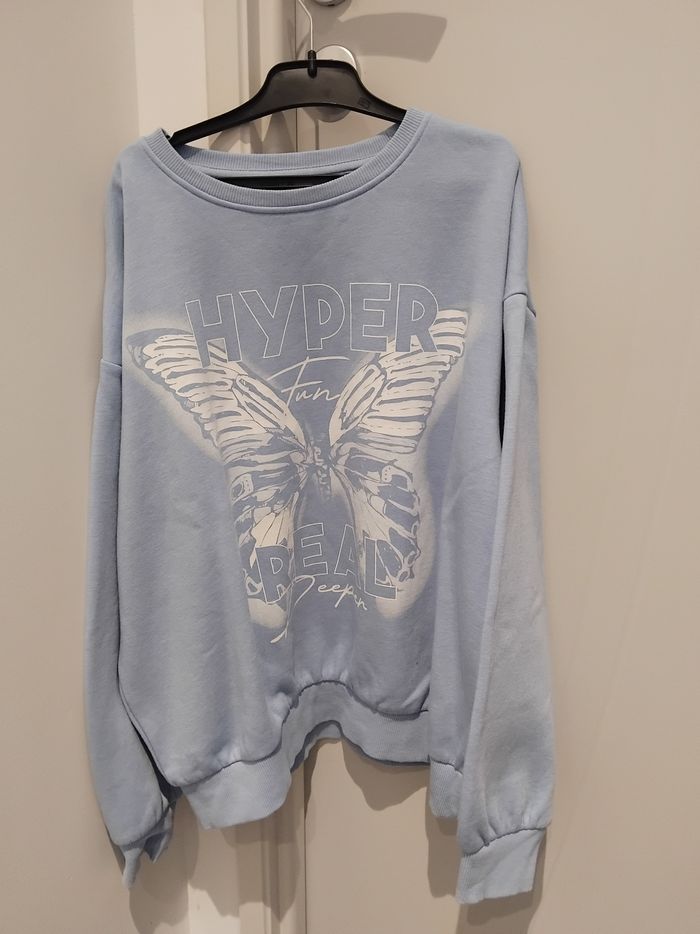 Pull bleu et papillon blanc