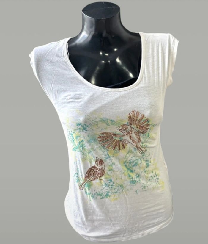 T-shirt blanc avec un joli imprimé oiseaux et touches brillantes. Taille 36