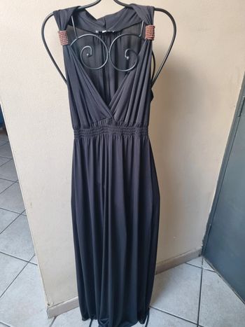 Longue robe noire unie avec decoration en bois aux épaules.