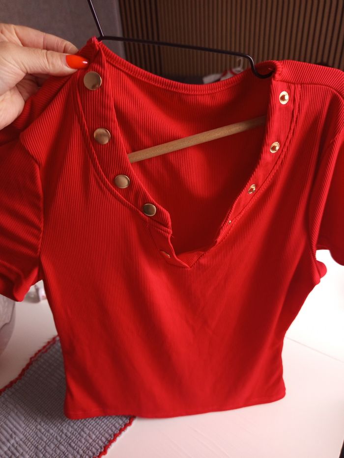 Top rouge à boutons dorés