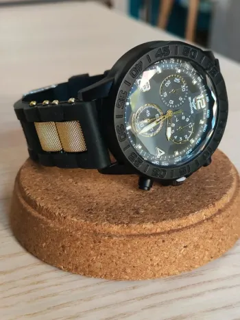 Montre robuste noire, dorée, reliefs, style sport