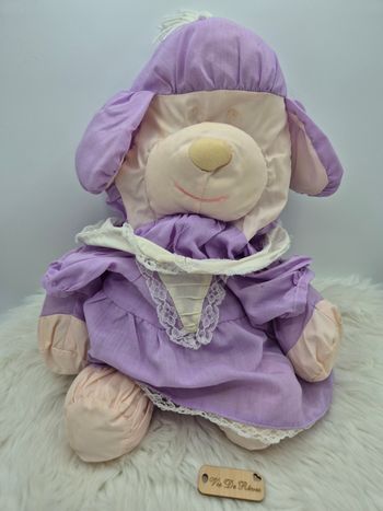 Doudou peluche Ours Chien Violet Puffalump
Robe, "dentelle"
Couleur : violet, blanc cassé, crème, écru 
Marque : Puffalump (fisher price ?)
État :  état satisfaisant, tout est visible en photo

Vous achetez le doudou que vous voyez. Entièrement vérifié. 
