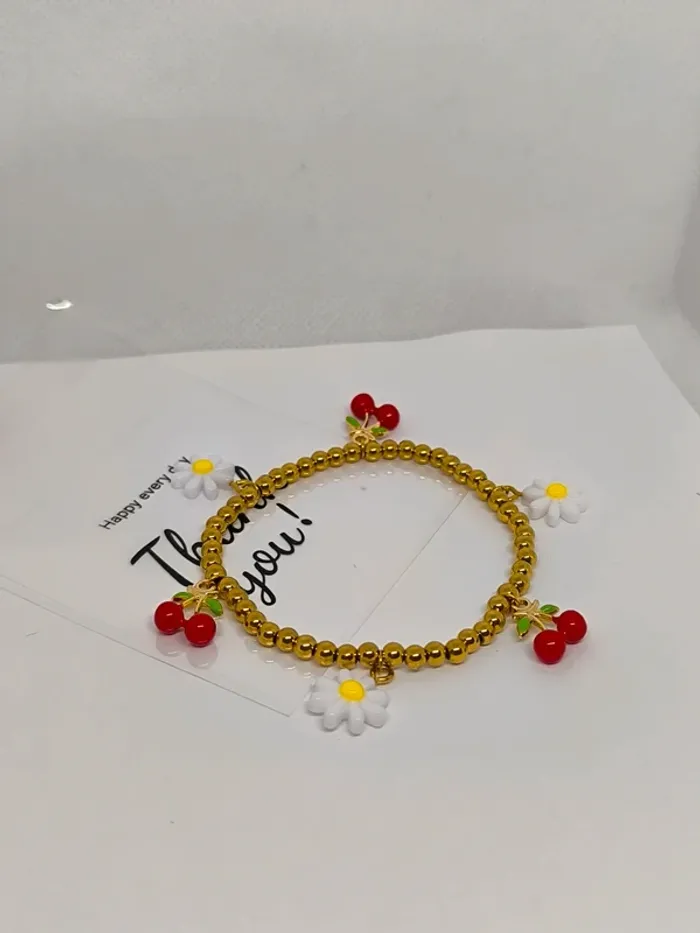 Bracelet doré élastique avec breloques cerises et marguerites blanches - photo numéro 5