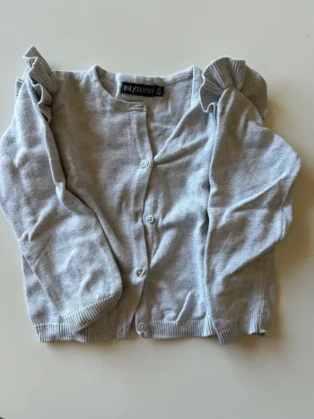 Gilet gris à volant sur les épaules
