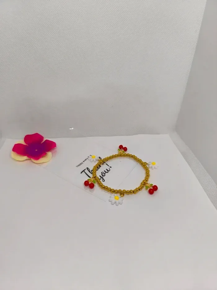 Bracelet doré élastique avec breloques cerises et marguerites blanches - photo numéro 4
