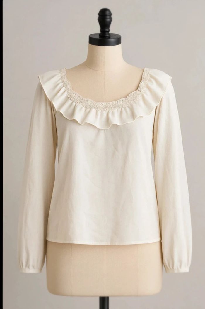 Blouse blanche manches longues et fines.