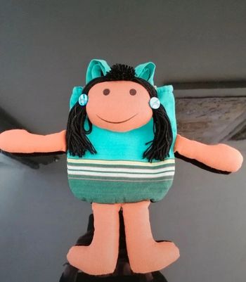 Sac à dos poupée métisse en tissu 40x20 cm.