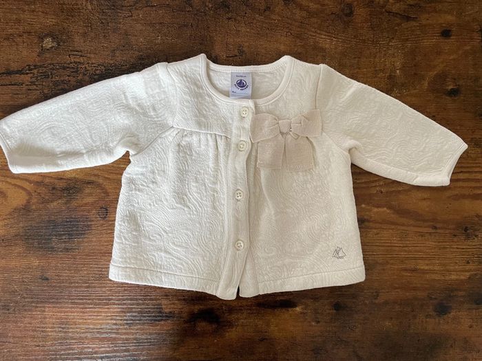 Veste molletonnée beige et dorée avec noeud