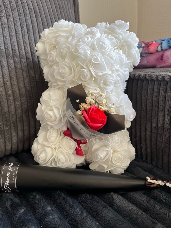Ours en fleurs de rose blanc avec une fleur rouge
