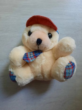 Peluche nounours avec casquette.