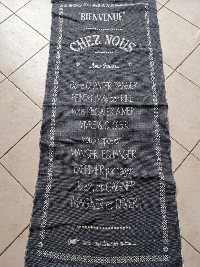 Tapis en tissu. Couleur bleu/gris avec impressions.