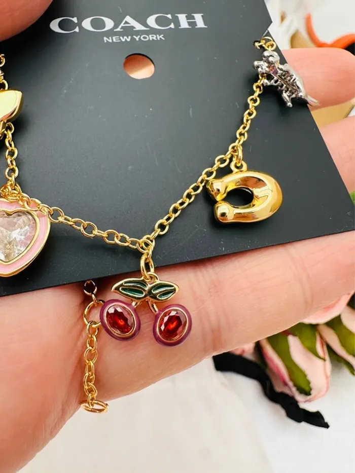 🦖Bracelet charms doré Coach New York – Papillon, cœur, cerises, logo C doré, dinosaure - photo numéro 3