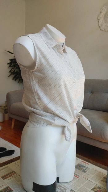 Chemise sans manche à pois noir sur fond blanc noué à la taille