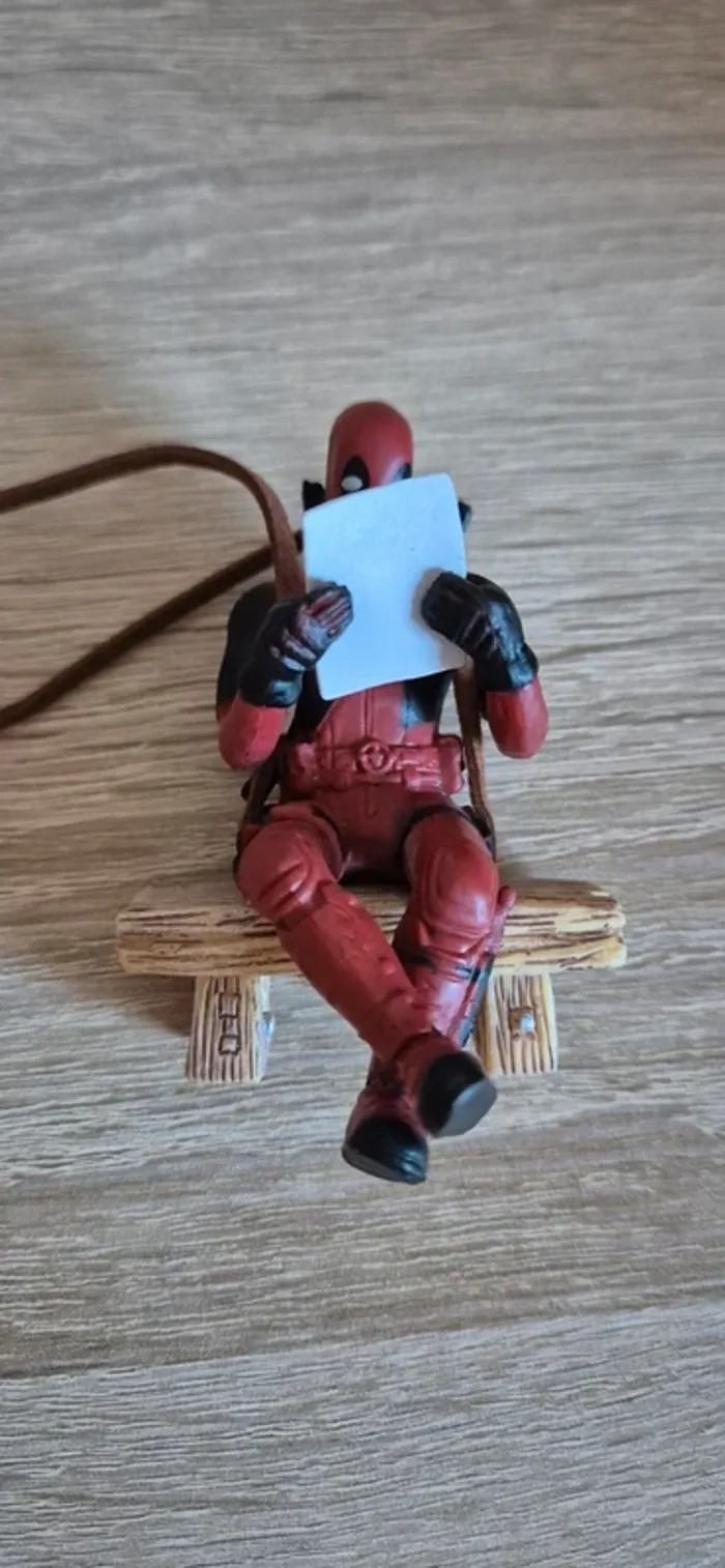 Figurine DeadPool suspendu assis sur un banc. - photo numéro 4
