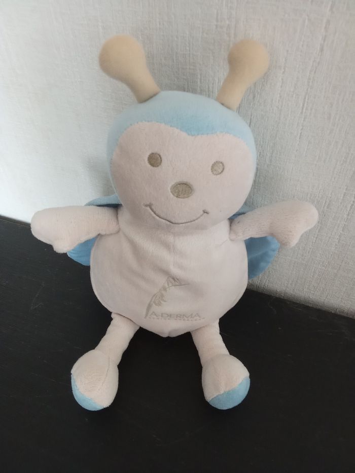Gros doudou, peluche coccinelle bleu ciel, beige marque aderma