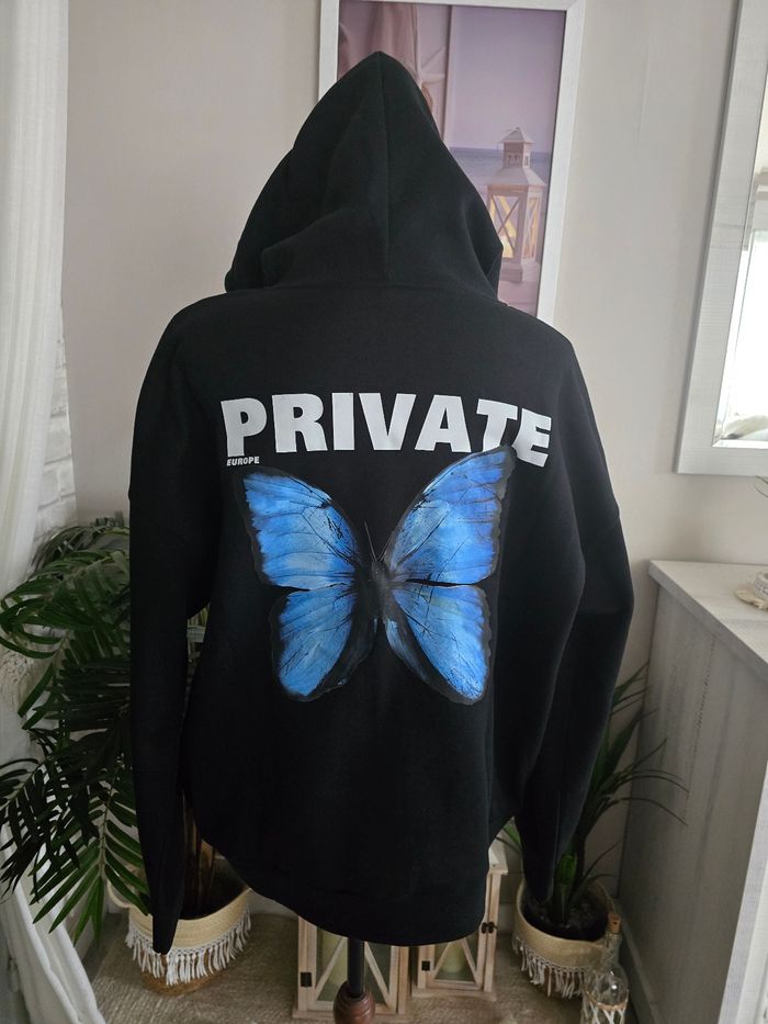 Sweat-shirt noir à capuche avec papillon bleu