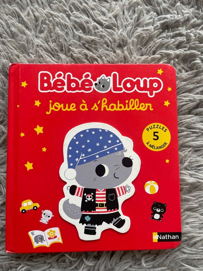 Livre-puzzle bébé loup joue à s'habiller