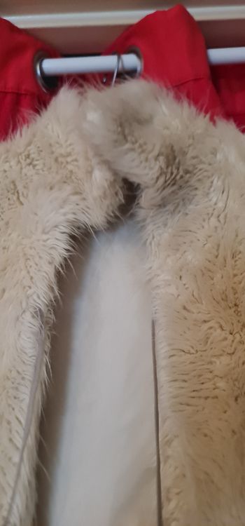 Veste fourrure synthétique sans manches avec petit laçage devant.