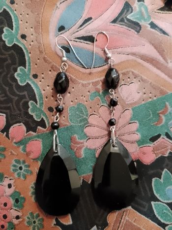 boucles d'oreilles pendantes en métal argenté et perles en verre noir.