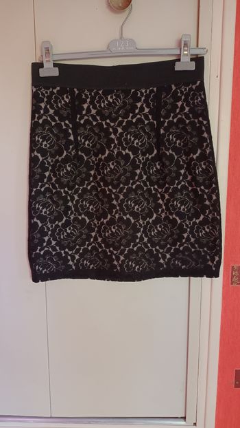 Jupe courte en dentelle noir avec doublure épaisse  de couleur beige .