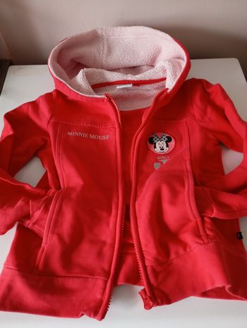 Sweat zippé avec capuche. 5/6 ans . 110/116 cm .Rouge .Noir gris ,rose, paillettes. Coton.  2 poches . Fermeture éclair métal.Disney Minnie Mouse.Très bon état.