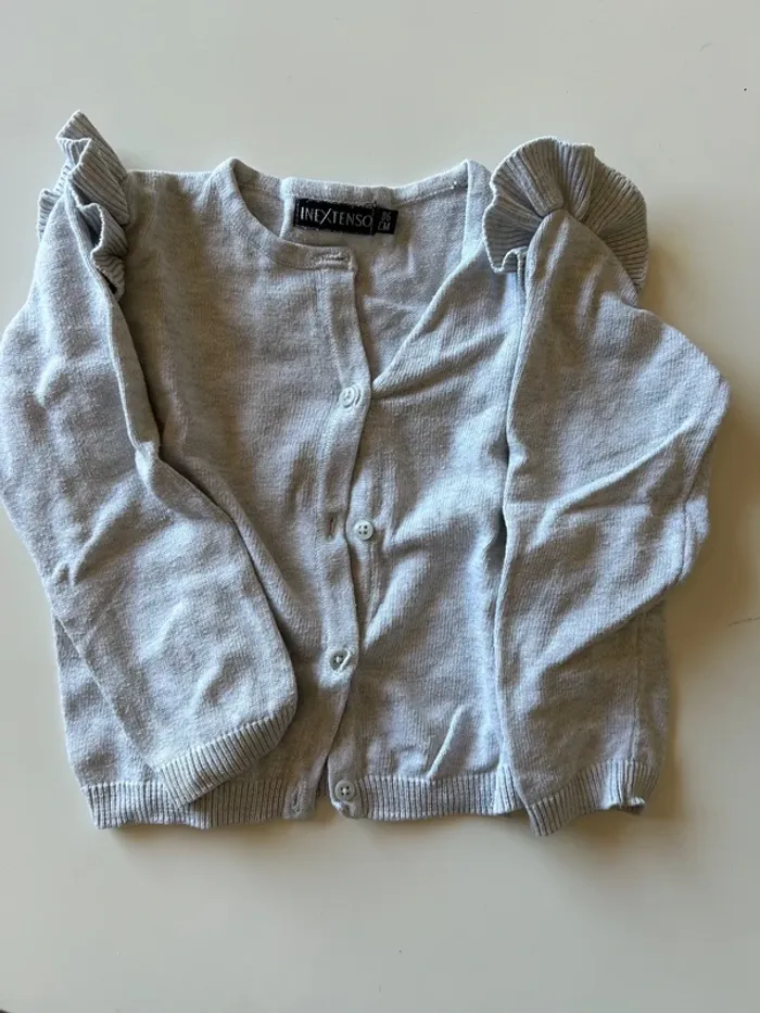 Gilet gris à volant sur les épaules