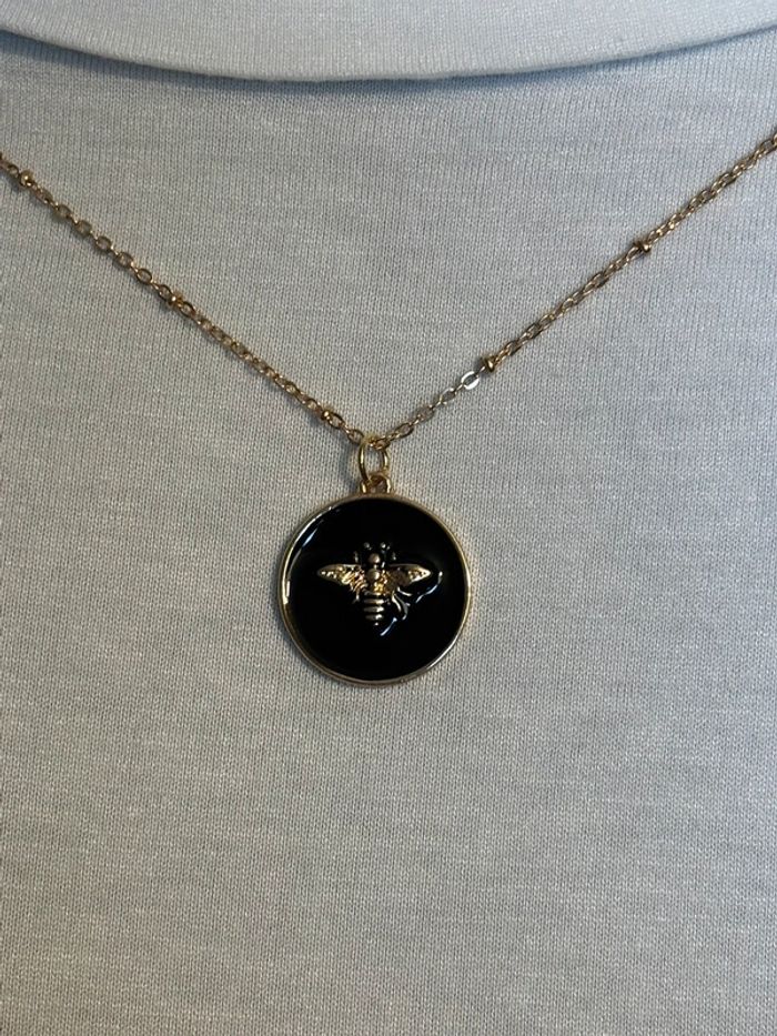 Pendentif abeille doré sur email noir monté sur chaîne courte dorée avec