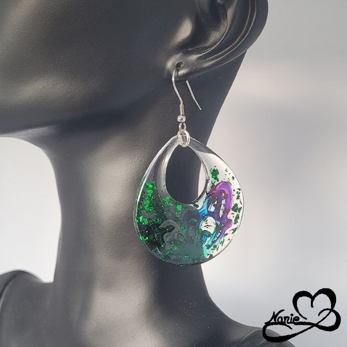 Boucles d'oreilles transparentes avec des papillons colorés et des feuilles vertes