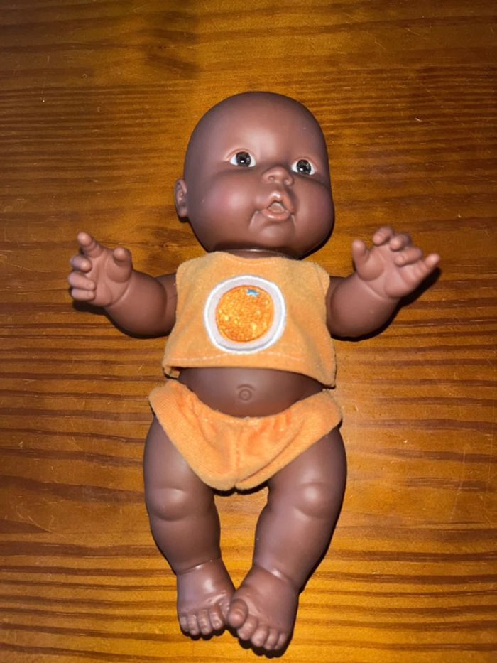 Petit poupon noir avec vêtements orange