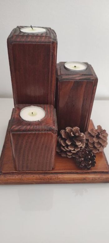 Bougeoirs en bois teinté couleur merisier et vernis sur support en bois.