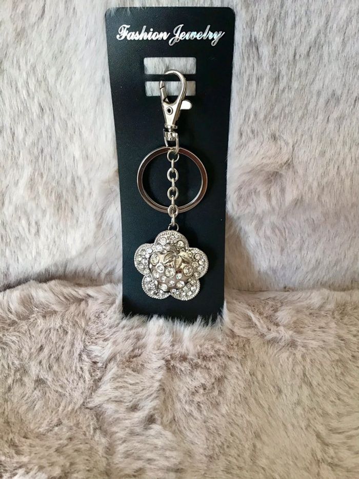 Jolie porte clef en métal argenté et strass fleur fraise (0124)