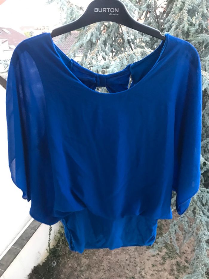 Haut bleue avec noeud dans le dos