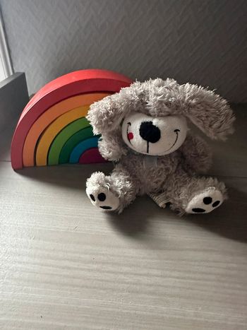 Peluche petit chien gris coquin la langue en coin.