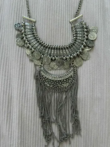Collier plastron argenté style ethnique avec pièces et chaînes.