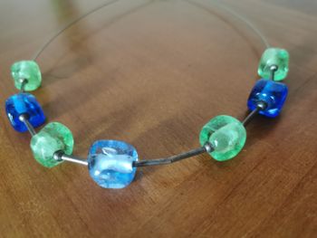 Collier de perles de verre vert et bleu sur un câble argenté