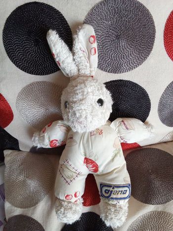 Doudou peluche lapin blanc de la marque Ajena vintage ancien blanc tissu bouclettes éponge corps tissu modèle hochet grelot petit 28 cm +/- oreilles incluses tissu blanc cassé crème  imprimé fruits panier chapeau 