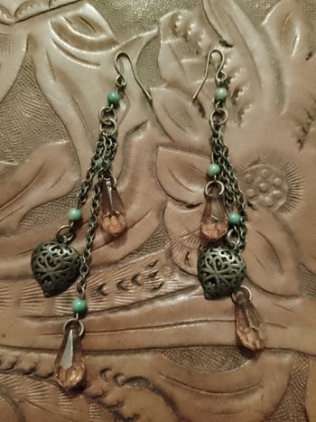 boucles d'oreilles en métal et perles oranges en plastique pendantes.