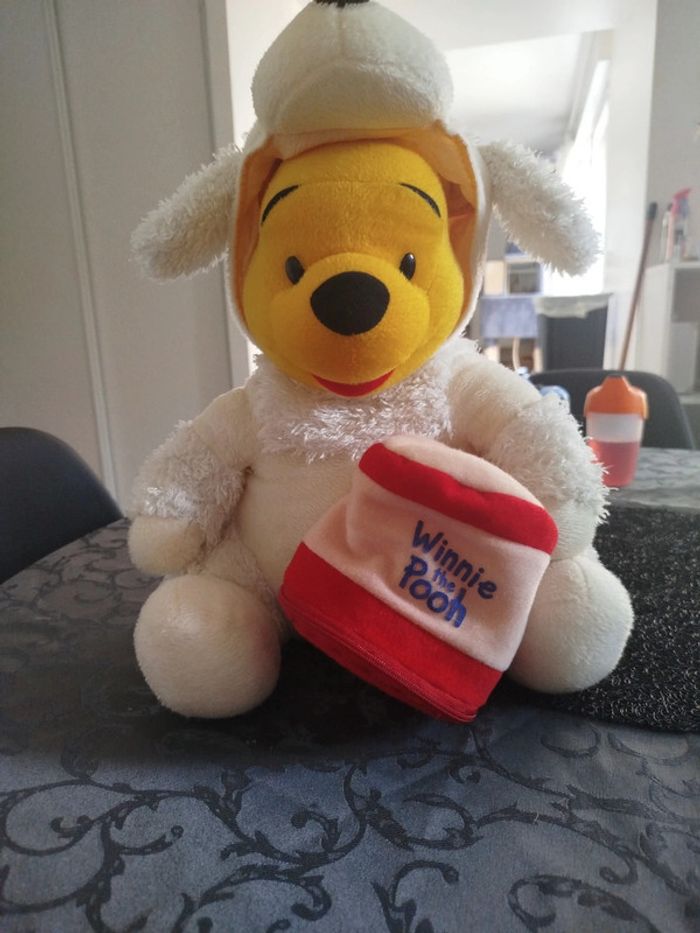 Peluche Winnie l'ourson assis déguisé en mouton