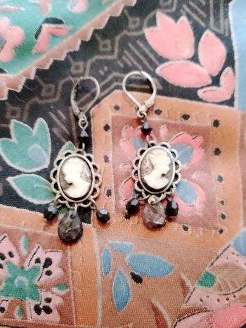boucles d'oreilles en plastique camés noirs sur métal foncé.