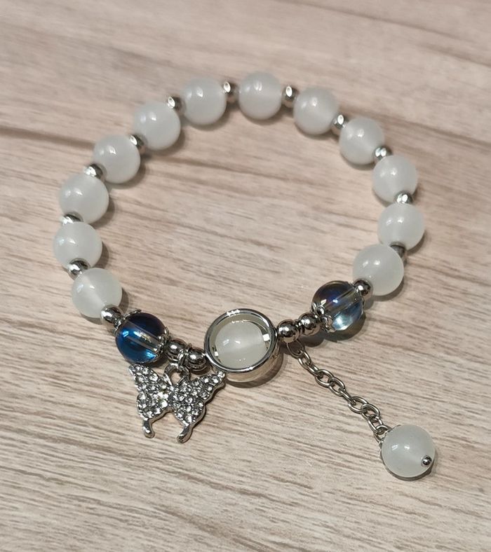 Bracelet élastique avec perles blanches et pendentif papillon argenté et zirconiums - photo numéro 2